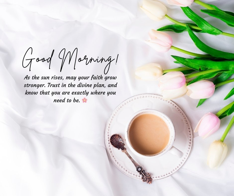 A serene image featuring a white cup of coffee on a saucer with an antique spoon, placed on a soft white fabric beside a bouquet of light pink tulips. The image includes a spiritual message that reads: "Good morning! As the sun rises, may your faith grow stronger. Trust in the divine plan, and know that you are exactly where you need to be." Perfect for sharing faith-filled morning inspiration.