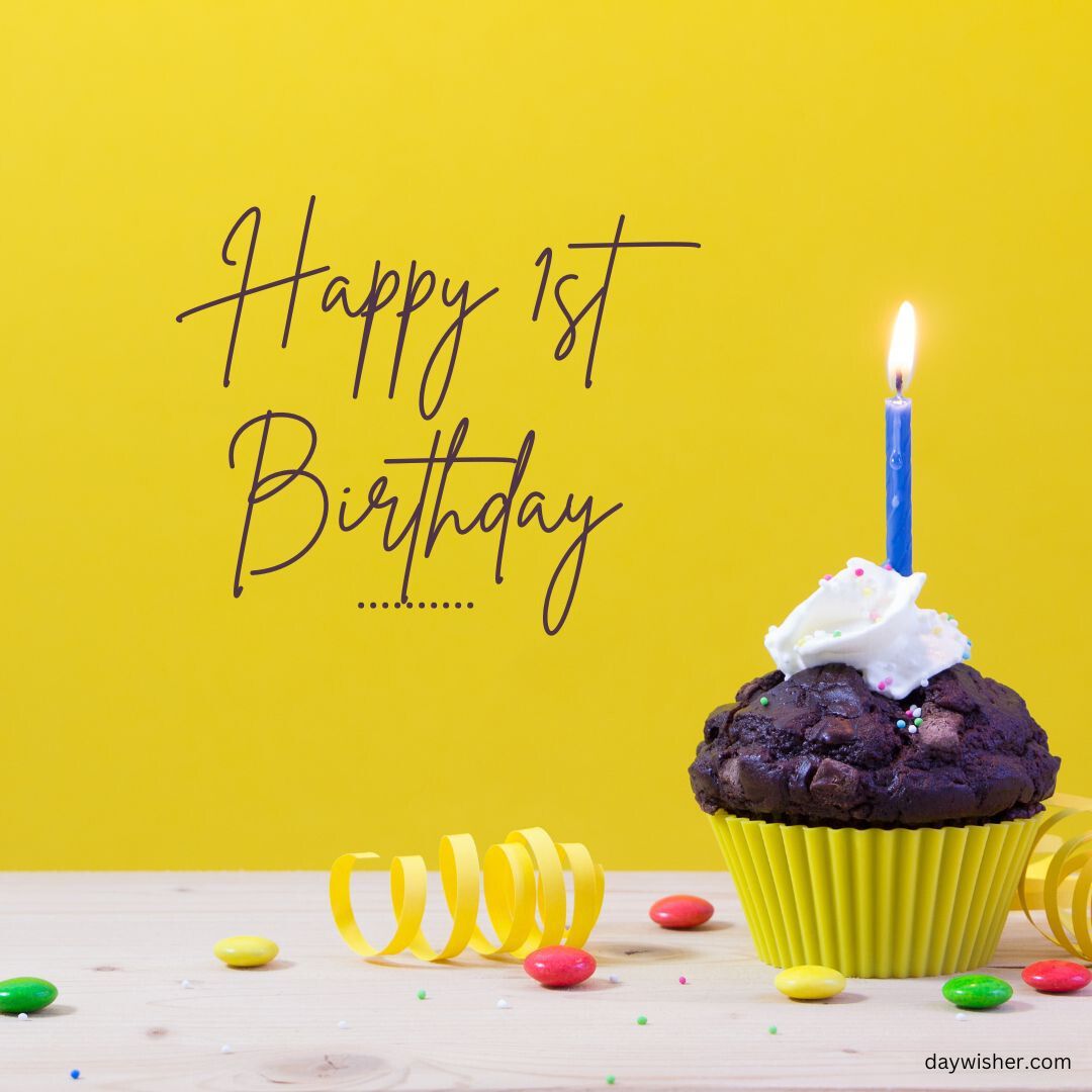 A chocolate muffin topped with white icing and a lit blue candle, surrounded by colorful candies on a wooden table, against a yellow background with "happy 1st birthday images" written in script.